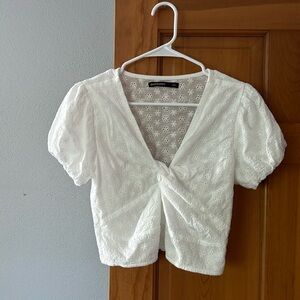 White shirt. Puffed sleeves, knotted in the middle. elastic  at back waistband.